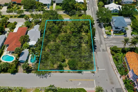 an aerial view of a house with a yard and couple of cars park