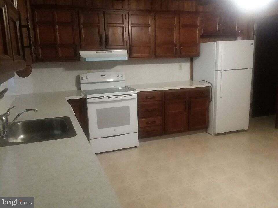 a kitchen with cabinets a refrigerator and a sink