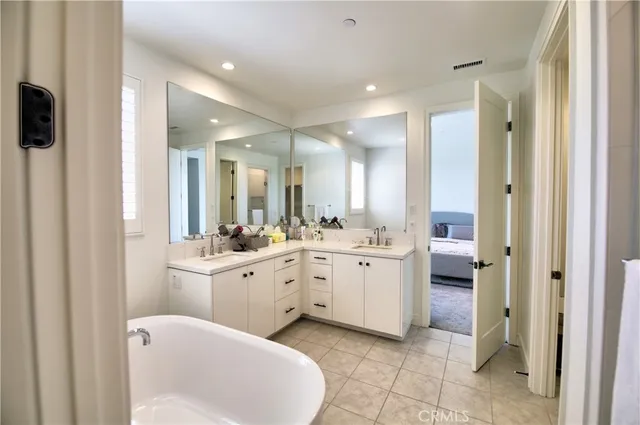 a large bathroom with a double vanity sink a mirror and a bathtub