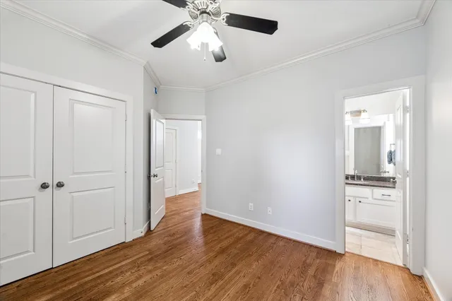 an empty room with wooden floor cabinet and windows