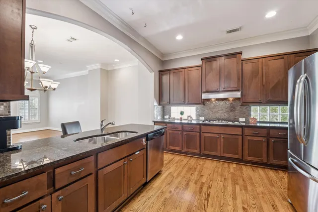 a kitchen with stainless steel appliances granite countertop a sink stove and refrigerator