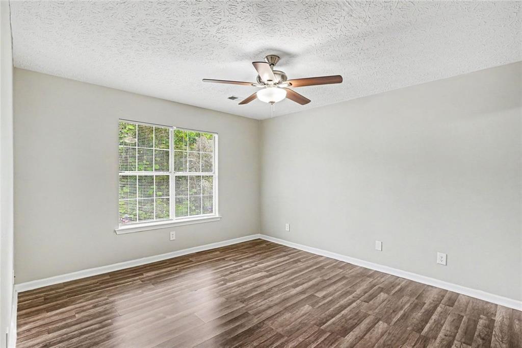 6221 Amberly Road Rex, GA 30273 - Photo 11 of 17 an empty room with wooden floor ceiling fan and windows