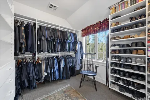 a view of walk in closet with clothes and shoes