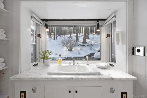 a bathroom with a granite countertop sink and a mirror