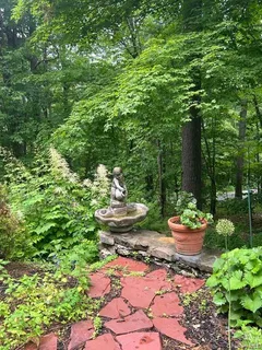 a backyard of a house with fountain table and chairs