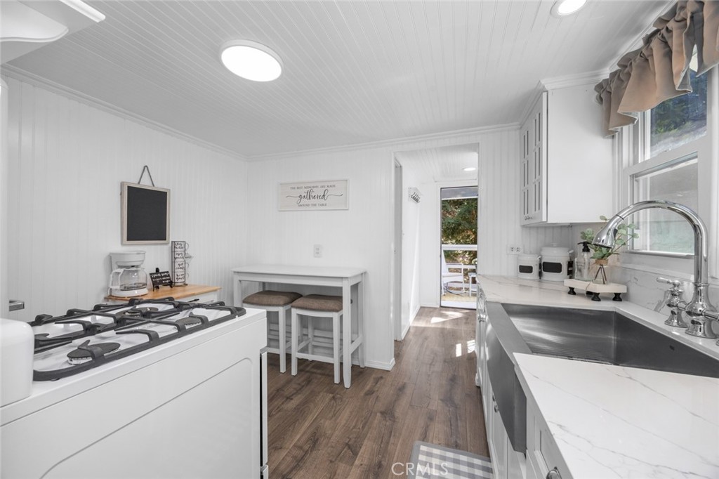 1177 Bear Springs Road Rimforest, CA 92378 - Photo 12 of 37 a kitchen that has a sink a stove and a wooden floor