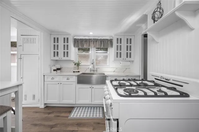 a kitchen with stainless steel appliances a white stove top oven and a sink with dishwasher