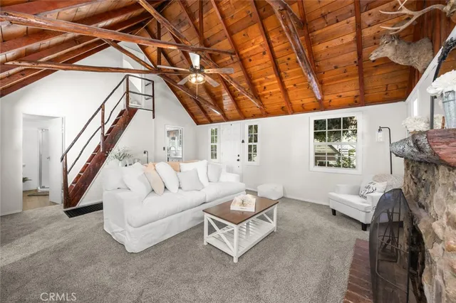 a living room with furniture a fireplace and a large window