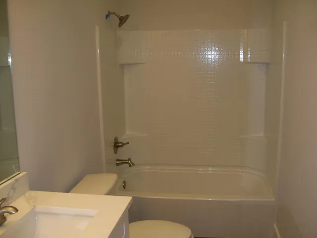 a bathroom with a shower a toilet and a sink