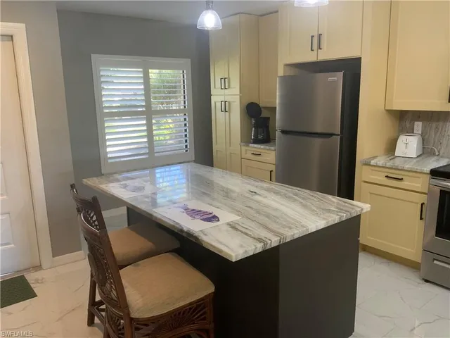 a kitchen with a table chairs refrigerator and cabinets