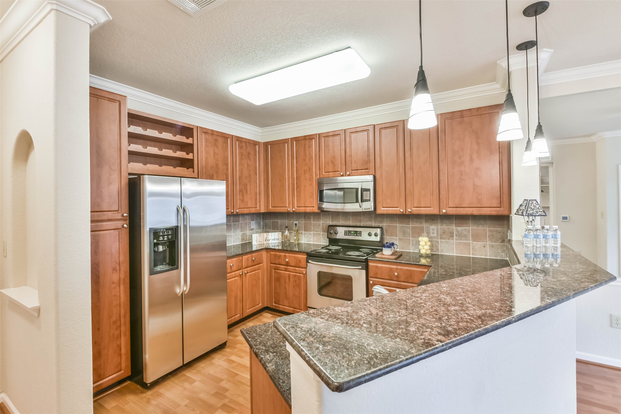 1711 Old Spanish Trail, Unit 406 Houston, TX 77054 - Photo 4 of 30 a kitchen with stainless steel appliances granite countertop a refrigerator a stove and a sink with wooden floor
