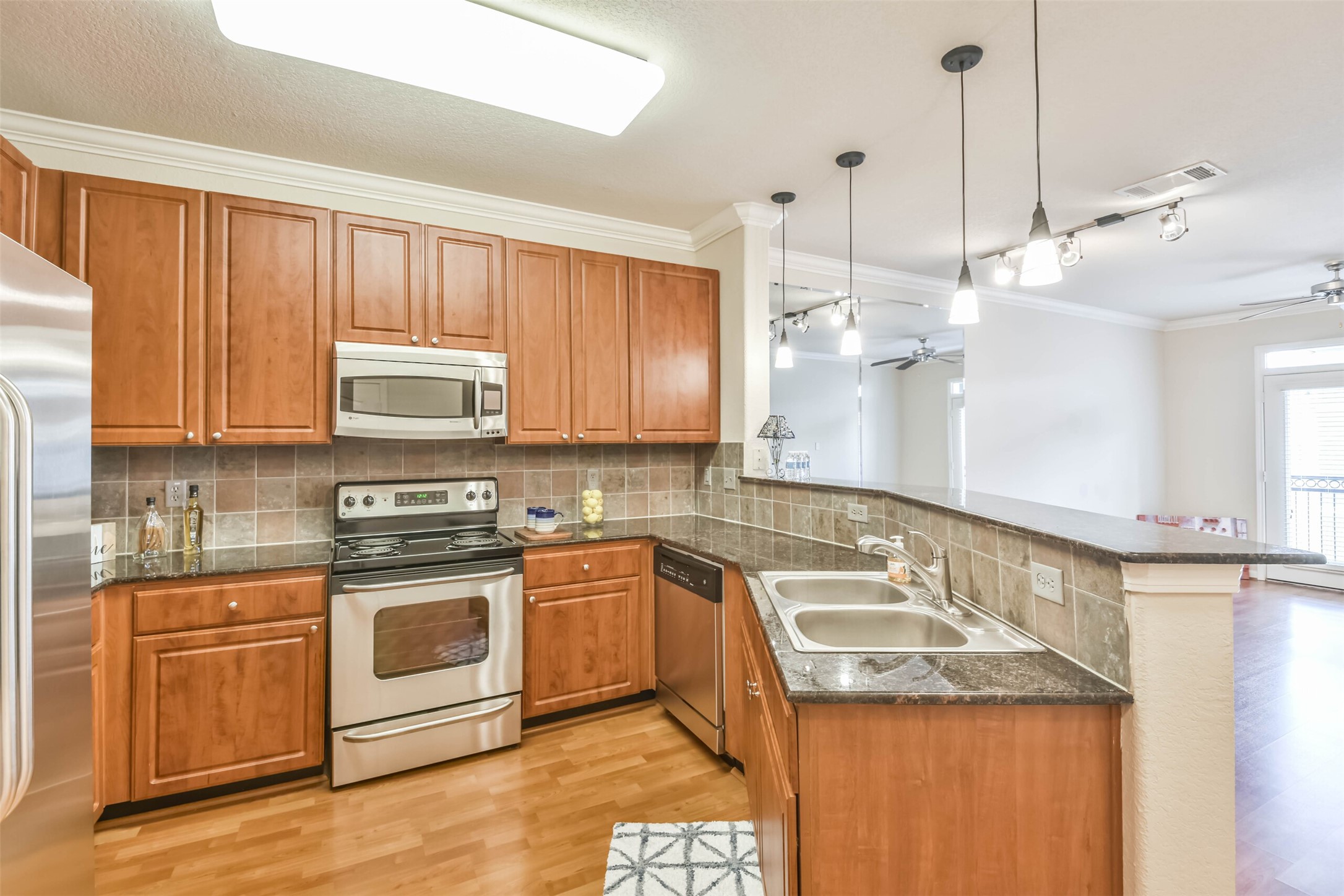 1711 Old Spanish Trail, Unit 406 Houston, TX 77054 - Photo 5 of 30 a kitchen with a sink a stove a microwave and cabinets