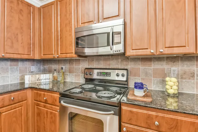 a kitchen with granite countertop wood cabinets and stainless steel appliances