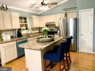 a kitchen with stainless steel appliances granite countertop a sink refrigerator and cabinets