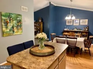 a dining room with furniture a chandelier and wooden floor