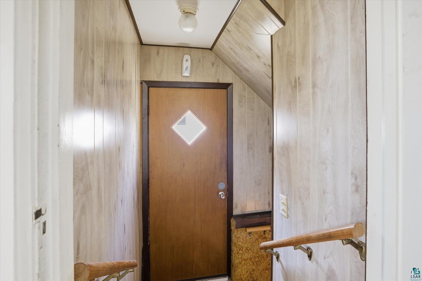 709 Michigan Street Hibbing, MN 55746 - Photo 35 of 47 Doorway to outside featuring wooden walls and vaulted ceiling