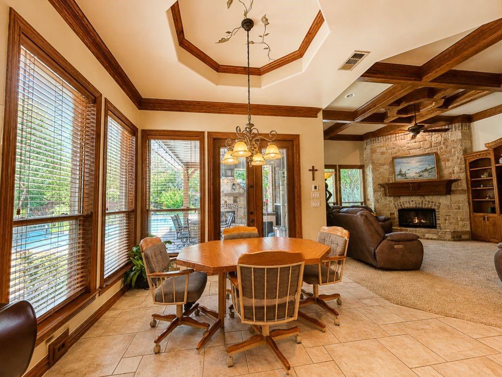 7005 Peter's Path Colleyville, TX 76034 - Photo 17 of 40 a dining room with furniture a chandelier and fireplace
