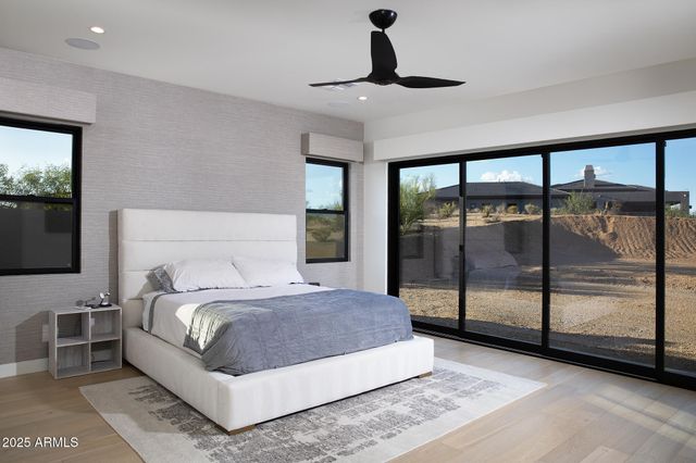 a bedroom with a large bed and a flat tv screen on dresser