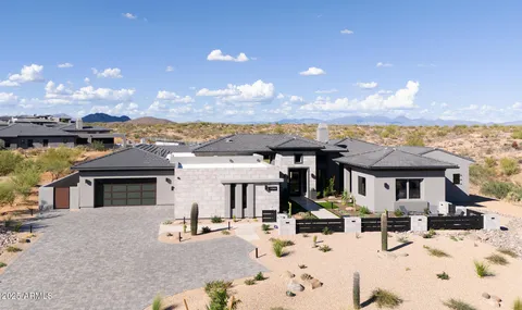 a front view of a house with a yard and mountain