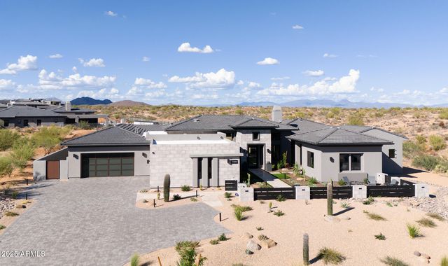 a front view of a house with a yard and mountain