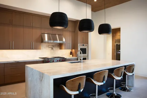 a kitchen with stainless steel appliances granite countertop a sink a stove and a refrigerator