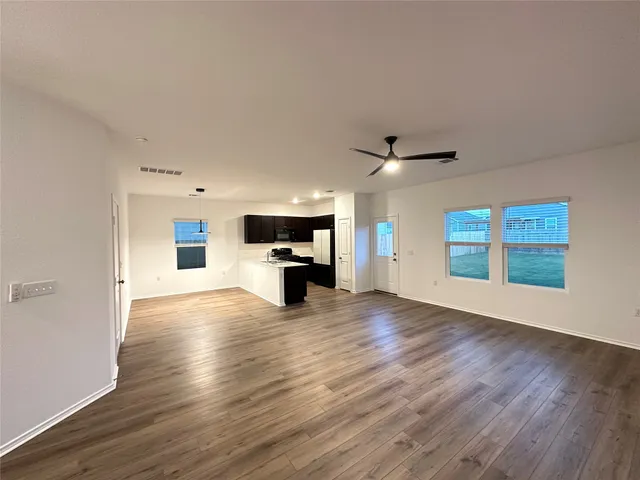 a view of empty room with wooden floor and window
