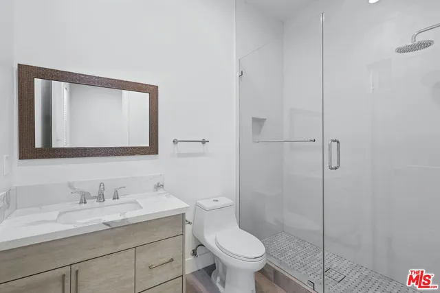 a bathroom with a granite countertop sink a toilet and a mirror