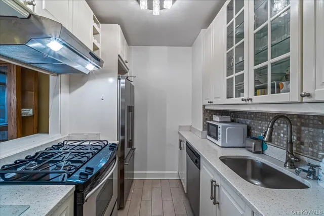a kitchen with stainless steel appliances granite countertop a sink stove and cabinets