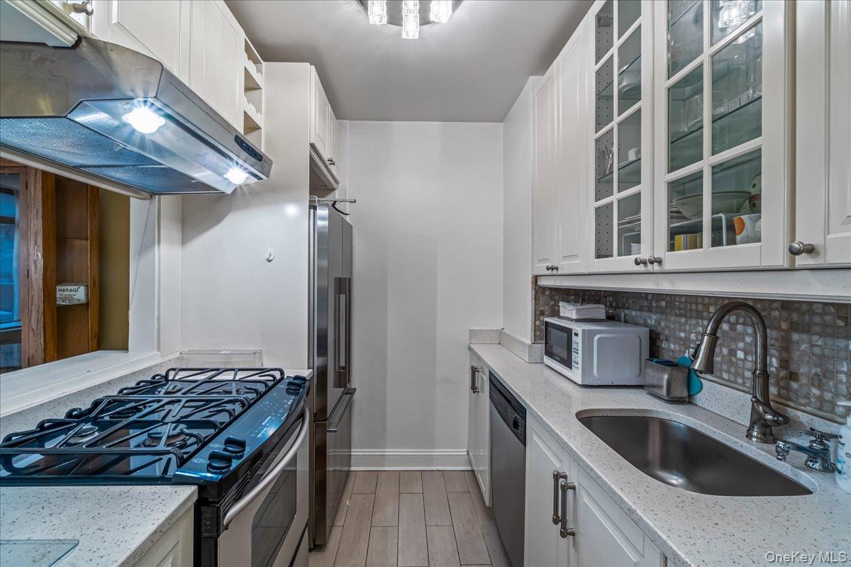 400 East 70th Street, Unit 201 Manhattan, NY 10021 - Photo 7 of 21 a kitchen with stainless steel appliances granite countertop a sink stove and cabinets