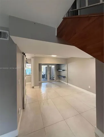a view of empty room with windows and cabinet