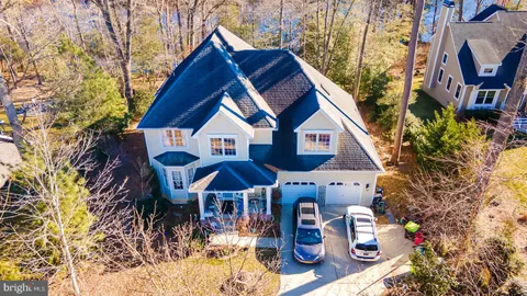 a aerial view of a house with table and chairs under an umbrella