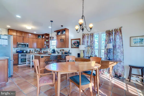 a dining area with a table chairs and a kitchen view