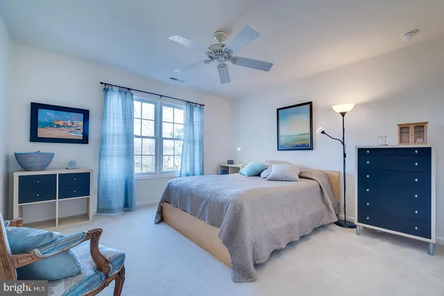 a view of a hallway to a room with wooden floor and windows