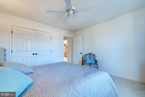 a spacious bedroom with a bed and a chandelier