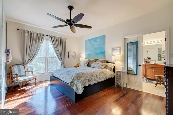 a spacious bedroom with a bed a chandelier and a large window