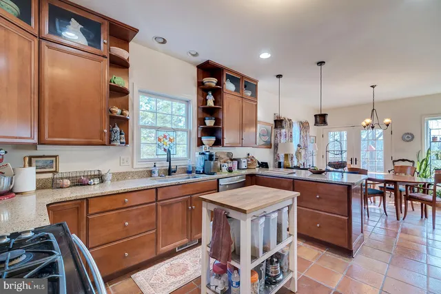 a kitchen with a sink a stove and chairs