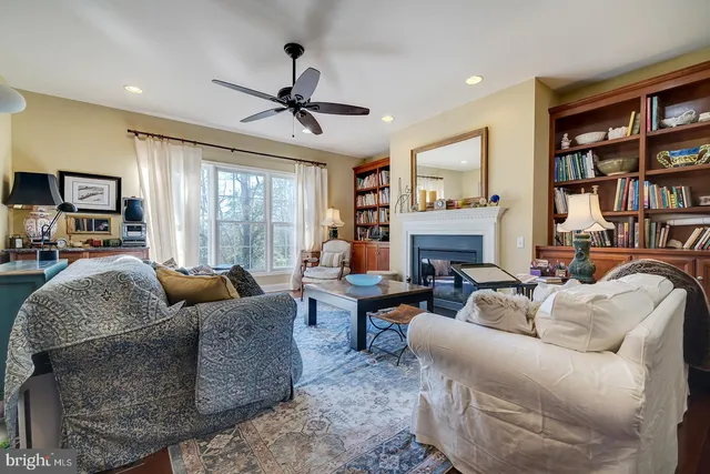 a living room with furniture fireplace and a large window