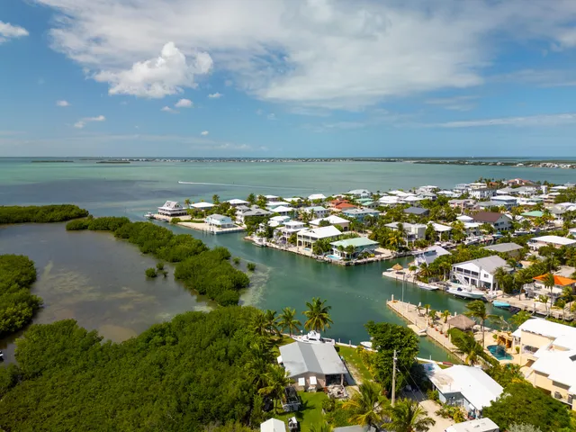 an aerial view of ocean and houses with outdoor space
