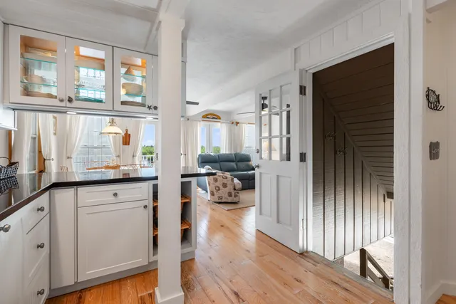 a hallway with white cabinets and wooden floor