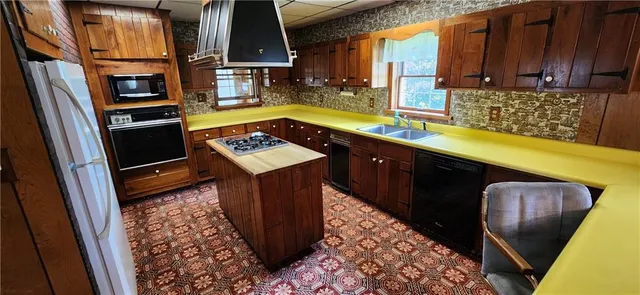 a kitchen with stainless steel appliances a stove a sink and a microwave