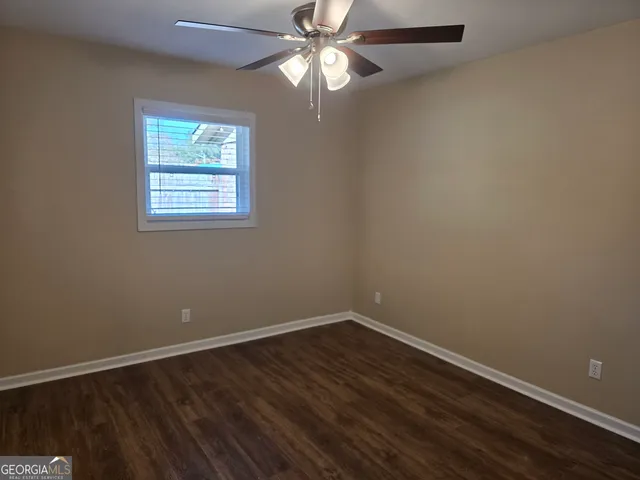 an empty room with a window and wooden floor