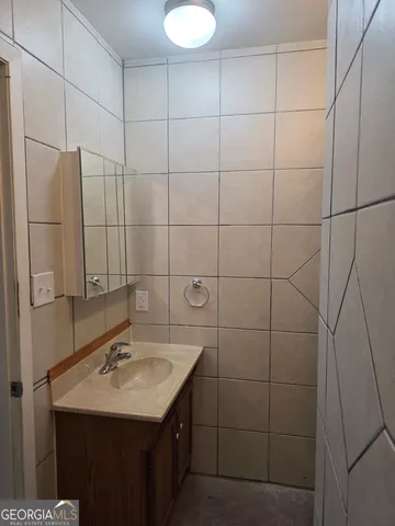 a bathroom with a sink shower and a mirror