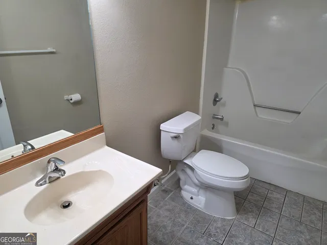 a bathroom with a sink toilet and a mirror