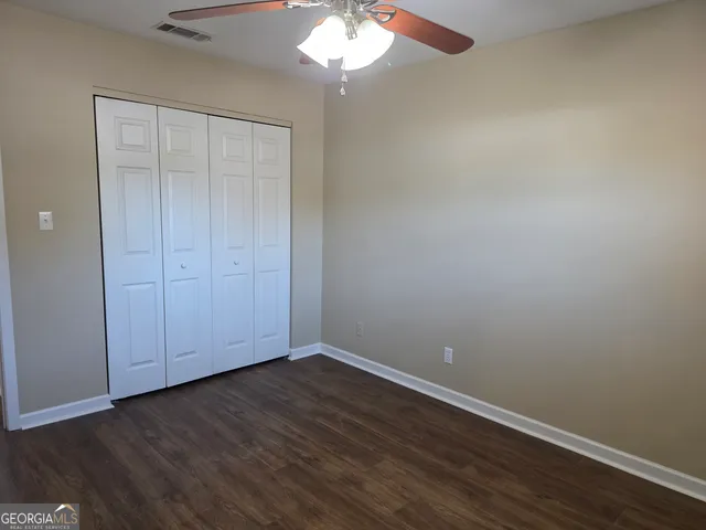 a view of an empty room with wooden floor