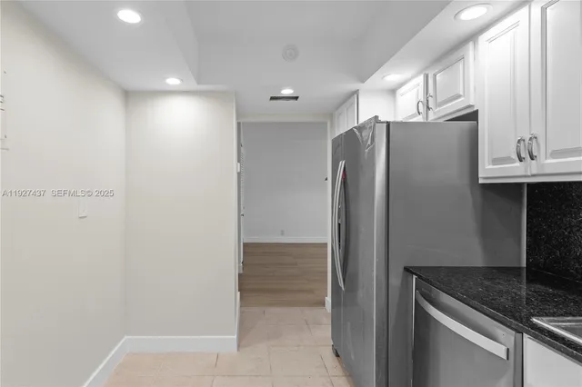 a kitchen with metallic refrigerator freezer and a sink