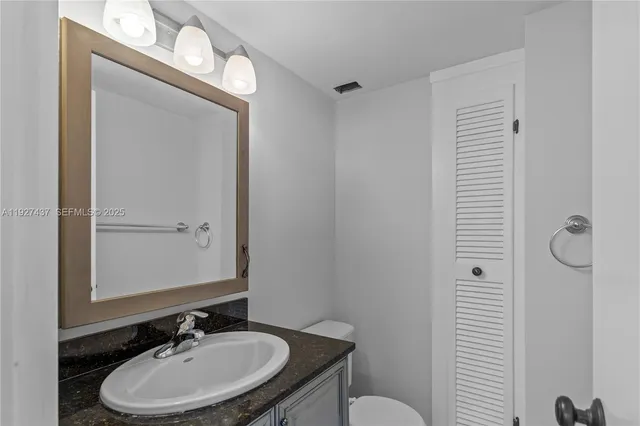 a bathroom with a sink a toilet and mirror