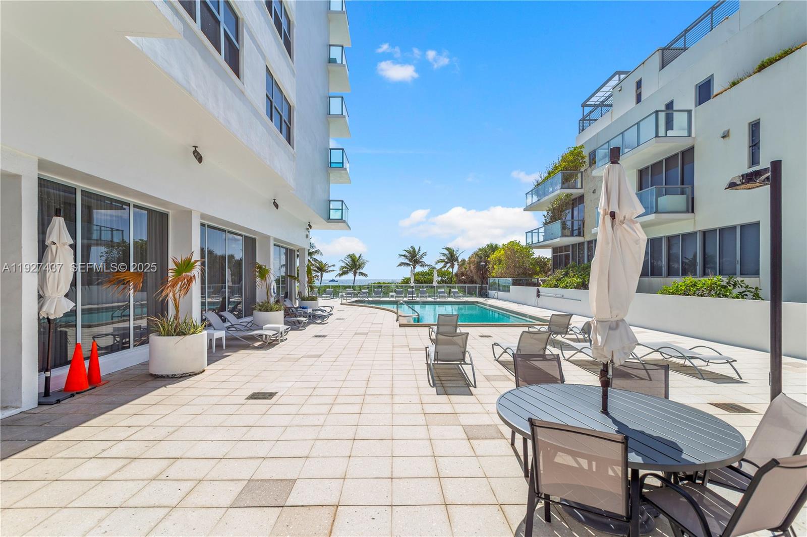 9511 Collins Avenue, Unit 806 Surfside, FL 33154 - Photo 25 of 32 a view of a patio with swimming pool table and chairs