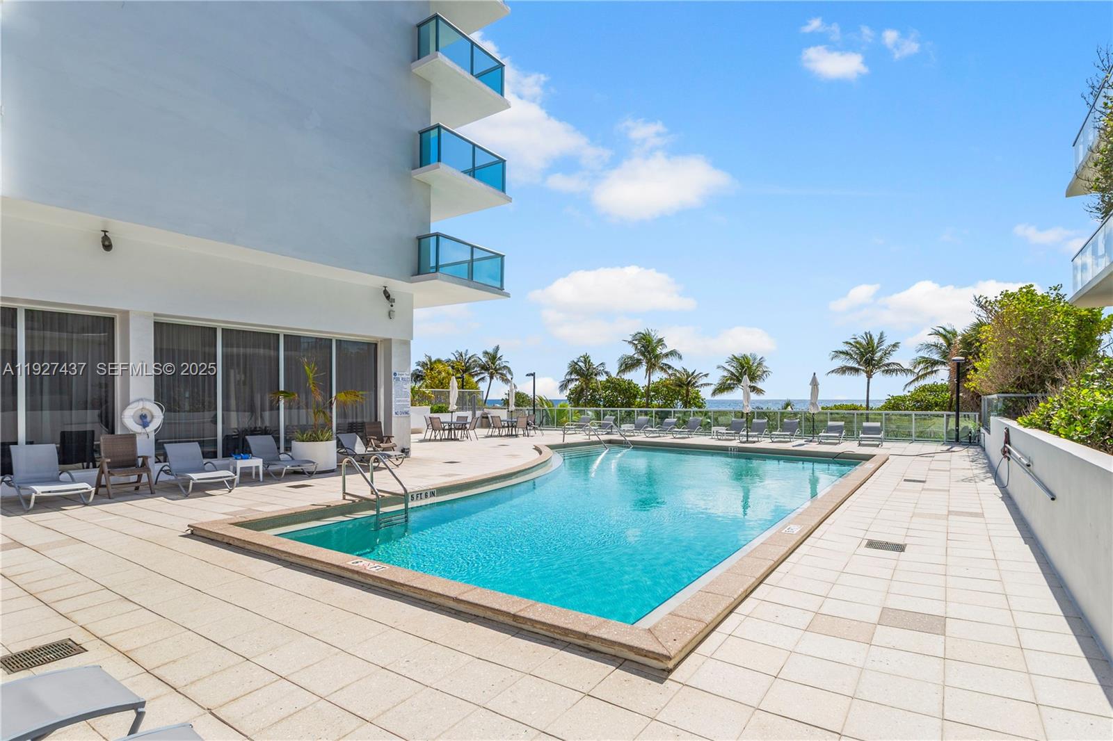 9511 Collins Avenue, Unit 806 Surfside, FL 33154 - Photo 26 of 32 a swimming pool with outdoor seating and yard
