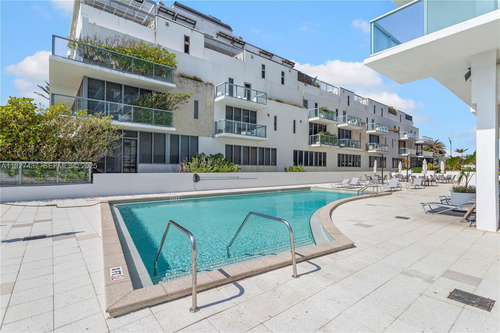 9511 Collins Avenue, Unit 806 Surfside, FL 33154 - Photo 29 of 32 a swimming pool with outdoor seating and yard