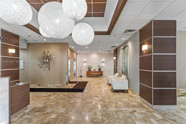 a view of a hallway with dining area and chandelier